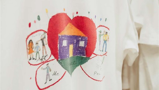 En teckning med ett hjärta och hem ritad på en t-shirt.